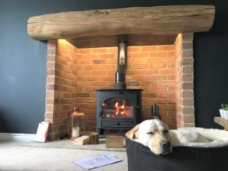 Oak mantel fitted above the fireplace with a dog sleeping