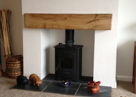 A fireplace with an oak beam mantel in the top