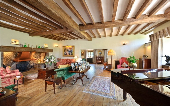 Oak framed lounge with a piano and a big fireplace.