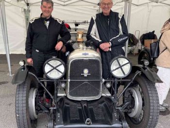 2 drivers posing in front of classic car