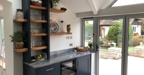 Wooden oak shelves above kitchen units.