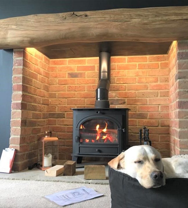 Oak mantel fitted above the fireplace with a dog sleeping