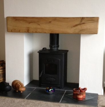 A fireplace with an oak beam mantel in the top