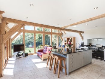 Oak framed sun room besides an open kitchen.