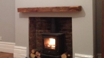 A fireplace light with an oak beam mantel in the top