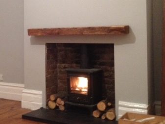A fireplace light with an oak beam mantel in the top