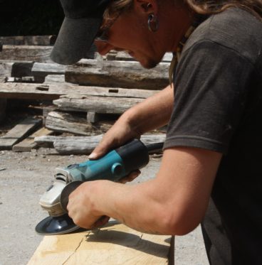 A man using a tool to give a finish to a piece of wood.